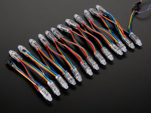 Array of many lit up LED pixel dots on wire strand, rainbow colored