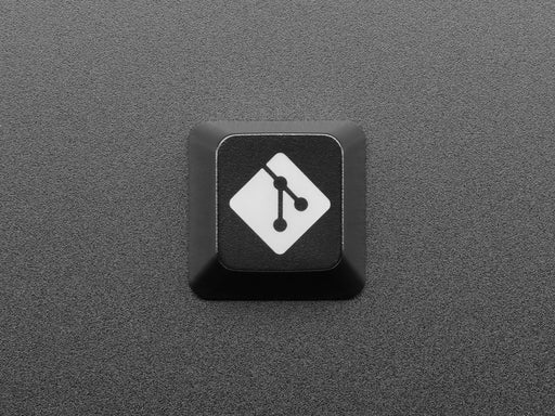 Top view video of black GIT logo keycap connected via USB cable. Various colors emit through the logo.