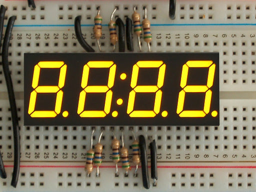 Overhead shot of a yellow LED module assembled on a breadboard with jumper wires and resistors. It displays 88:88 in yellow.