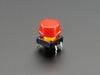 Top-down shot of 15 colorful round tactile button switches in green, yellow, red, blue, and white.