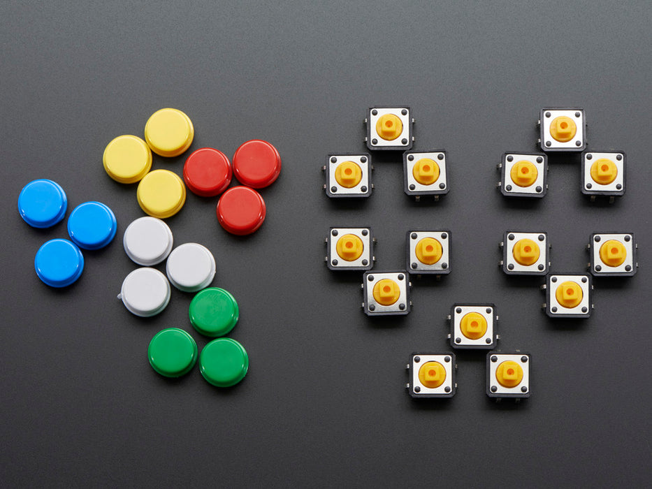 Top-down shot of 15 colorful round tactile button switches in green, yellow, red, blue, and white.