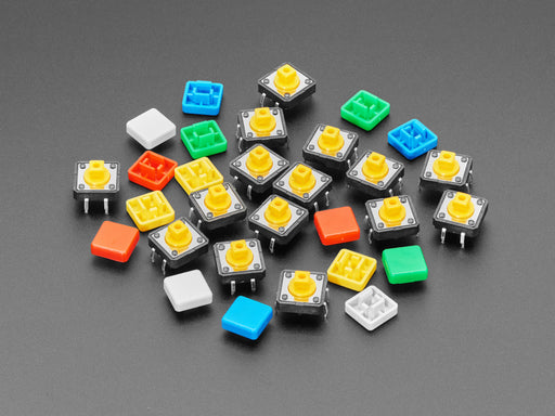 Angled  shot of 15 colorful square tactile button switches in green, yellow, red, blue, and white.