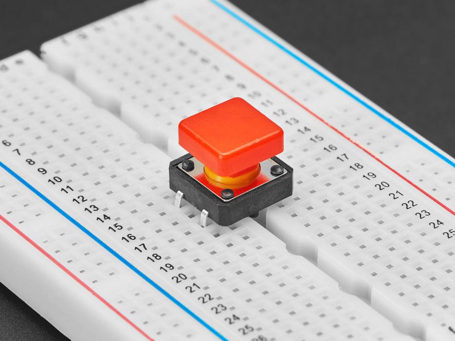 Angled  shot of 15 colorful square tactile button switches in green, yellow, red, blue, and white.
