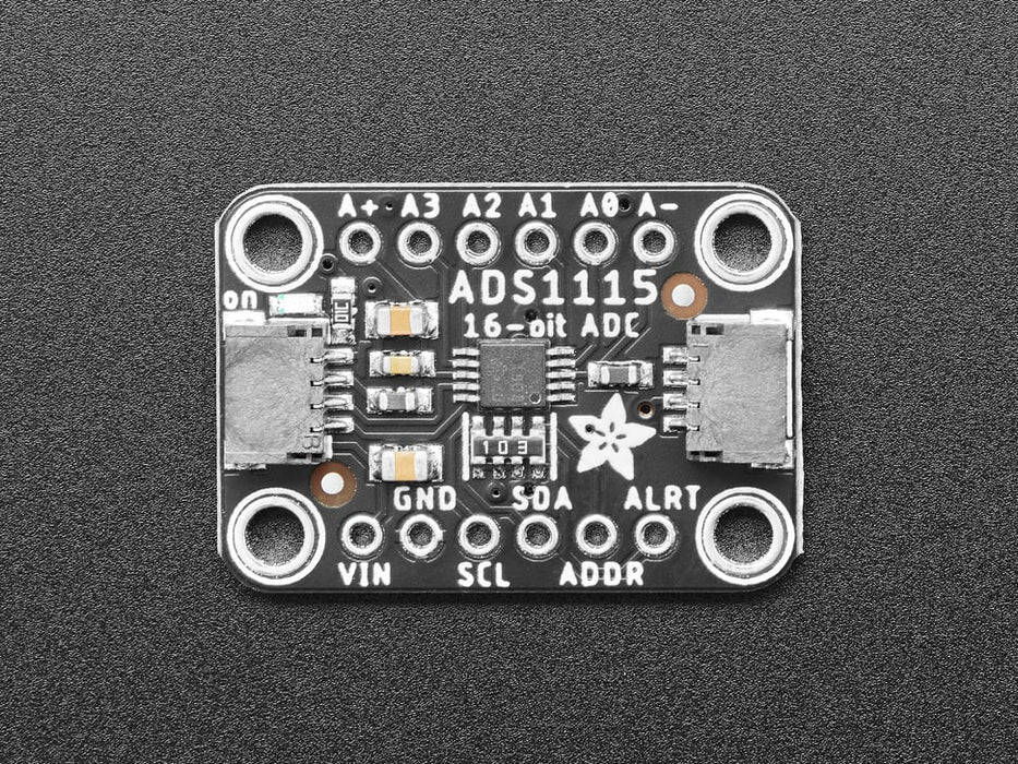 Angled shot of a black rectangular ADC breakout board.