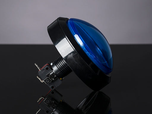 Head-on shot of illuminated massive blue 100mm arcade button.