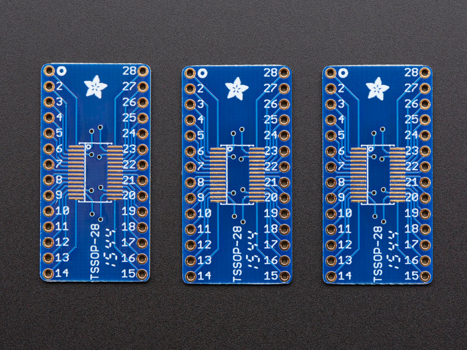 A pair of tweezers holding a microchip hovers over the SMT Breakout PCB for SOIC-28 or TSSOP-28.