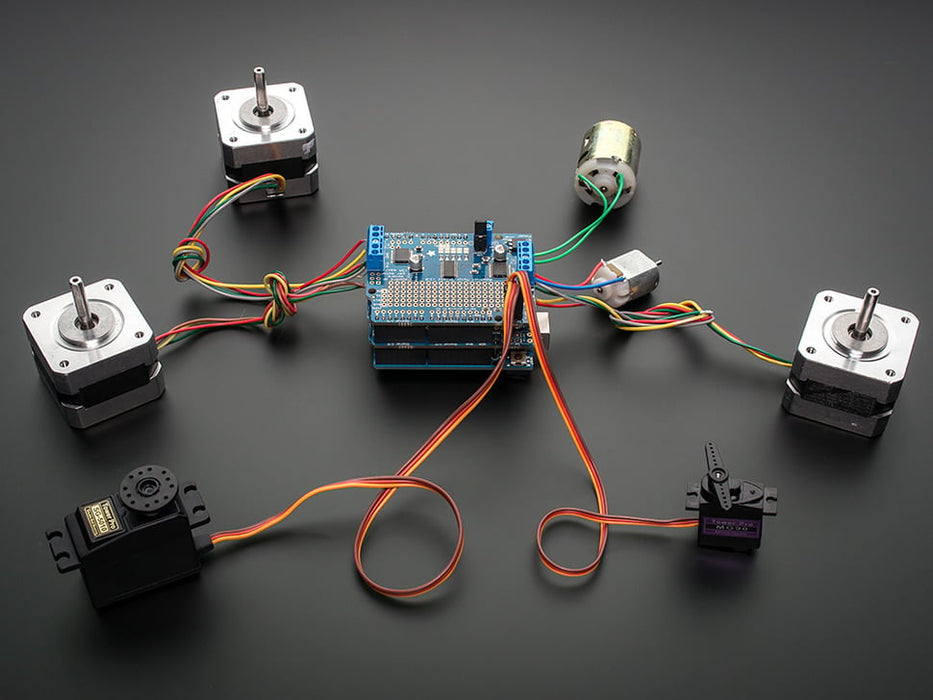 Angled shot of a Adafruit Motor/Stepper/Servo Shield for Arduino v2 Kit connected to several different steppers and servos. 