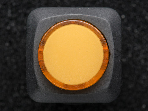 Angled shot of a yellow round 16mm illuminated pushbutton. 