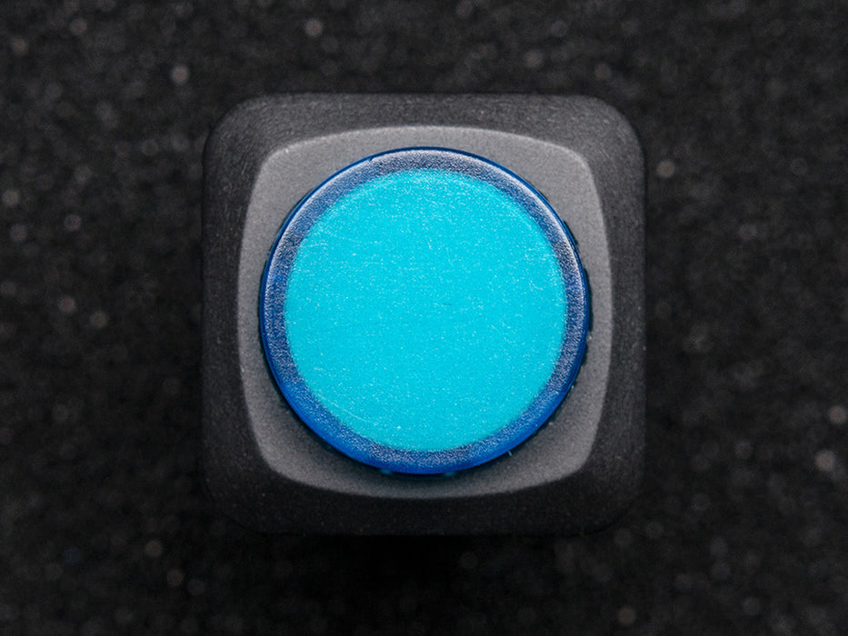 Angled shot of a blue round 16mm illuminated pushbutton. 