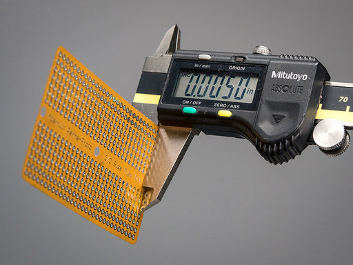 A white hand holding a Adafruit Flex Perma-Proto - Half-sized Breadboard Flex-PCB.