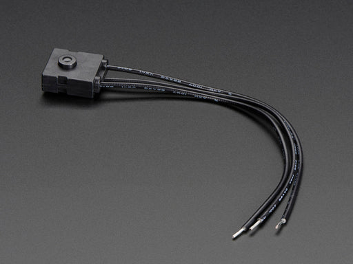 Head-on shot of black tactile alternating button with three wire leads.