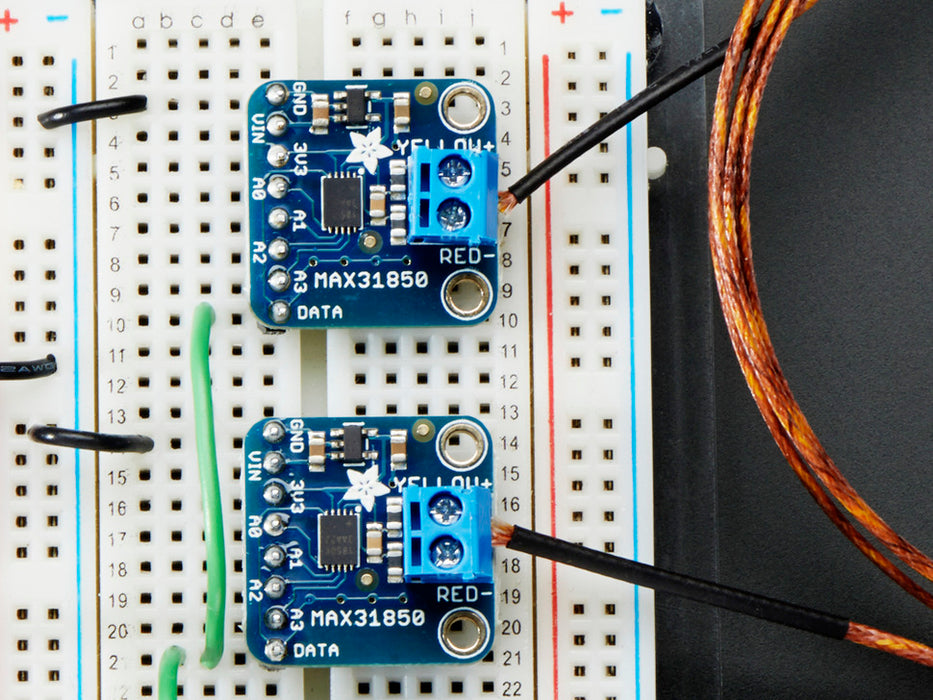 Top down view of a Thermocouple Amplifier with 1-Wire Breakout Board. Set of different kinds of headers to the left, a US quarter for scale to the right, and a resister below it. 