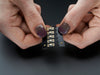 Single LED sequin PCB attached to two alligator clips, glowing red