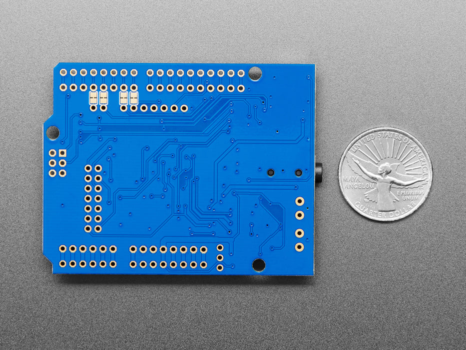 Angled shot of Adafruit "Music Maker" MP3 Shield for Arduino connected to a pair of headphones. 