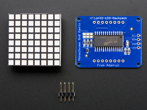 Close-up of Adafruit Small 1.2" 8x8 Blue LED Matrix w/I2C Backpack assembled and powered on. A blue graphic smiley is displayed.