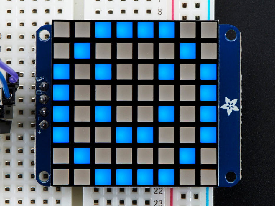 Close-up of Adafruit Small 1.2" 8x8 Blue LED Matrix w/I2C Backpack assembled and powered on. A blue graphic smiley is displayed.