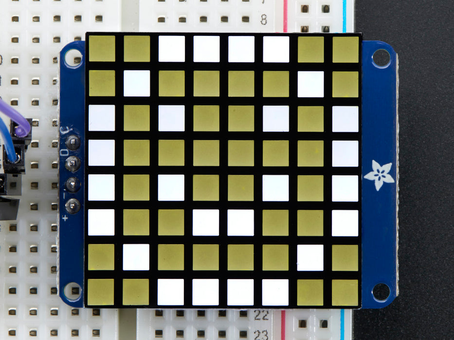 Close-up of soldered and assembled Small 1.2" 8x8 Ultra Bright Square White LED Matrix + Backpack on a breadboard powered by an Arduino Uno. The LED Matrix displays a white smiley.