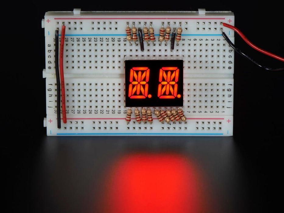 Red Dual Alphanumeric Display module wired to breadboard, all segments lit
