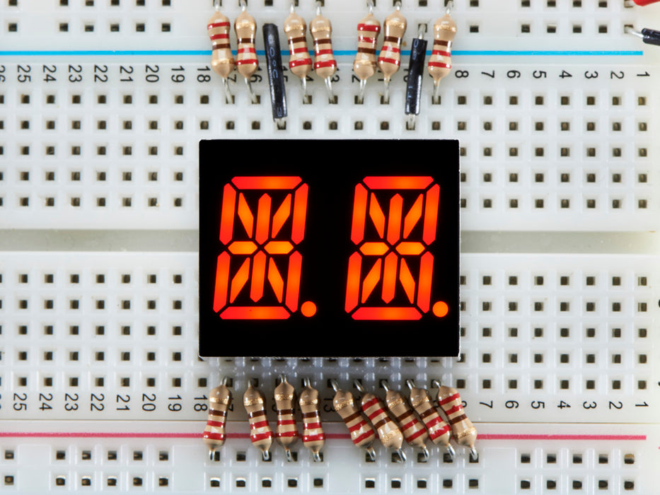 Red Dual Alphanumeric Display module wired to breadboard, all segments lit