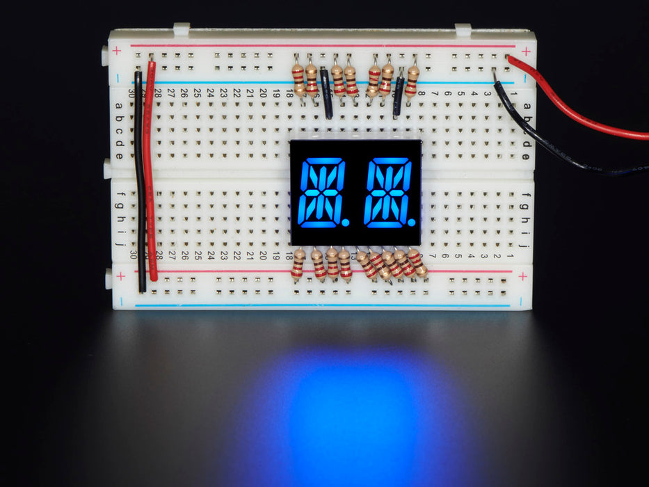 Blue Dual Alphanumeric Display module wired to breadboard, all segments lit