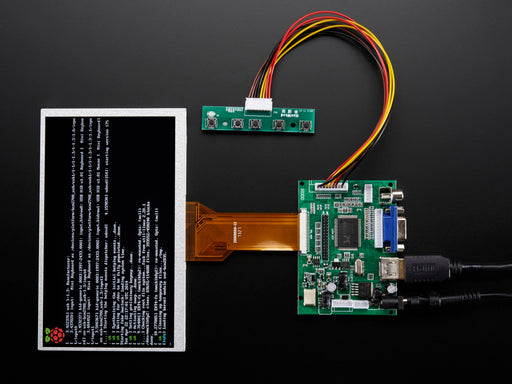 Angled shot of a HDMI 4 Pi: 7" Display no Touchscreen. The monitor displays a desktop background with a adafruit logo, raspberry logo, and a heart. 