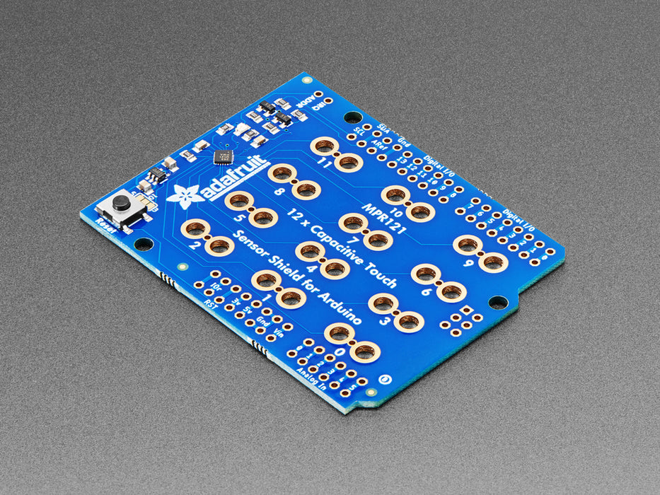 Top view of Capacitive Touch Shield for Arduino connected to various fruits and objects via alligator clips. 