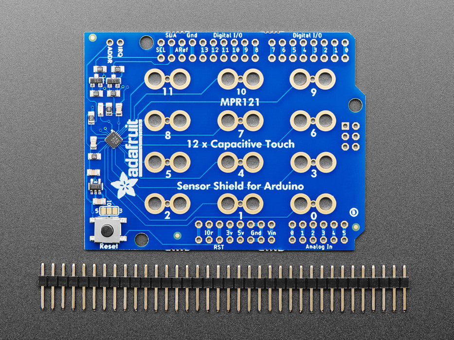 Top view of Capacitive Touch Shield for Arduino connected to various fruits and objects via alligator clips. 