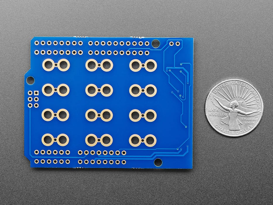 Top view of Capacitive Touch Shield for Arduino connected to various fruits and objects via alligator clips. 