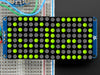 Close-up of Soldered and assembled 16x8 1.2" LED Matrix + Backpack - Ultra Bright Round Yellow-Green LEDs on a breadboard. The LED Matrices display a smiling emoji and a frowning emoji.