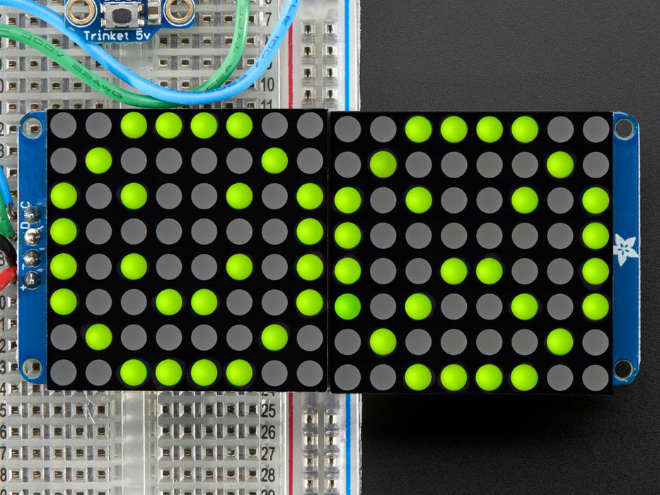 Close-up of Soldered and assembled 16x8 1.2" LED Matrix + Backpack - Ultra Bright Round Yellow-Green LEDs on a breadboard. The LED Matrices display a smiling emoji and a frowning emoji.