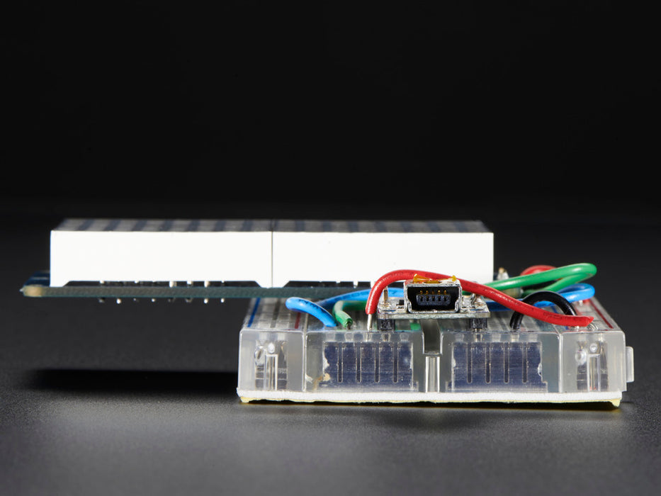 Close-up of Soldered and assembled 16x8 1.2" LED Matrix + Backpack - Ultra Bright Round Yellow-Green LEDs on a breadboard. The LED Matrices display a smiling emoji and a frowning emoji.