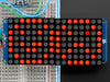 Close-up of Soldered and assembled 16x8 1.2" LED Matrix + Backpack - Ultra Bright Round Red LEDs on a breadboard. The LED Matrices display a smiling emoji and a frowning emoji.