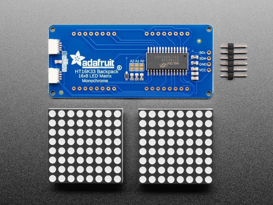 Close-up of Soldered and assembled 16x8 1.2" LED Matrix + Backpack - Ultra Bright Round Red LEDs on a breadboard. The LED Matrices display a smiling emoji and a frowning emoji.