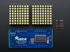 Close-up of Soldered and assembled 16x8 1.2" LED Matrix + Backpack - Ultra Bright Round White LEDs on a breadboard. The LED Matrices display a smiling emoji and a frowning emoji.