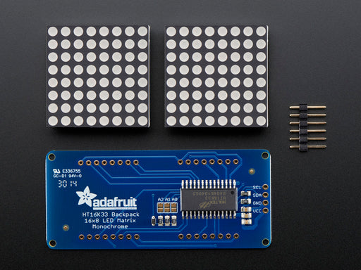 Close-up of Soldered and assembled 16x8 1.2" LED Matrix + Backpack - Ultra Bright Round Blue LEDs on a breadboard. The LED Matrices display a smiling emoji and a frowning emoji.