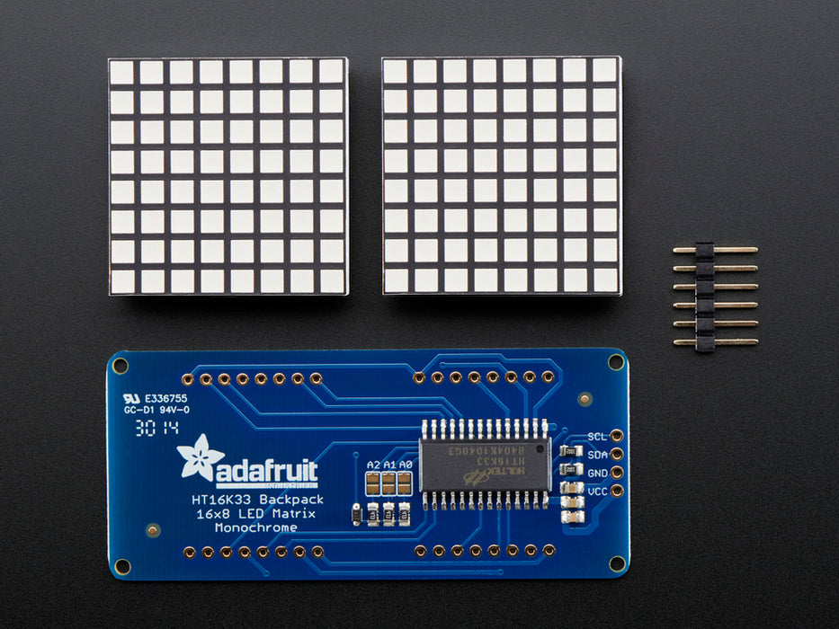 Close-up of Soldered and assembled 16x8 1.2" LED Matrix + Backpack - Ultra Bright Square Amber LEDs on a breadboard. The LED Matrices display a smiling emoji and a frowning emoji.