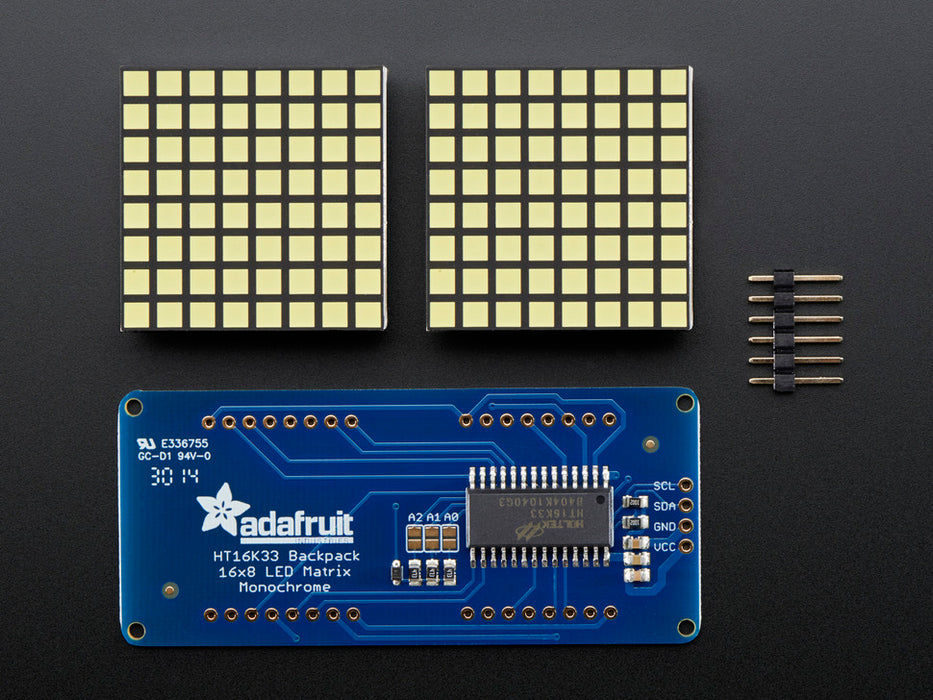 Close-up of Soldered and assembled 16x8 1.2" LED Matrix + Backpack - Ultra Bright Square White LEDs on a breadboard. The LED Matrices display a smiling emoji and a frowning emoji.