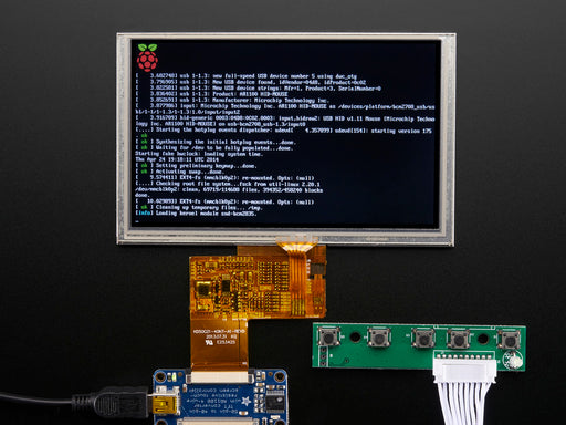 Angled shot of an assembled HDMI 4 Pi: 5" Display w/Touch and Mini Driver. The HDMI screen displays a desktop image including the Adafruit logo, the Raspberry Pi logo, and a pink heart.