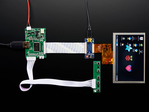 Angled shot of an assembled HDMI 4 Pi: 5" Display w/Touch and Mini Driver. The HDMI screen displays a desktop image including the Adafruit logo, the Raspberry Pi logo, and a pink heart.