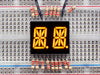 Yellow Dual Alphanumeric Display module wired to breadboard, all segments lit