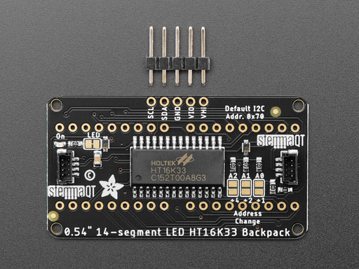 Overhead shot of an assembled 14-segment LED backpack, emitting the follow text in white LEDS: "AdaFruit 14-Segment Backpack"