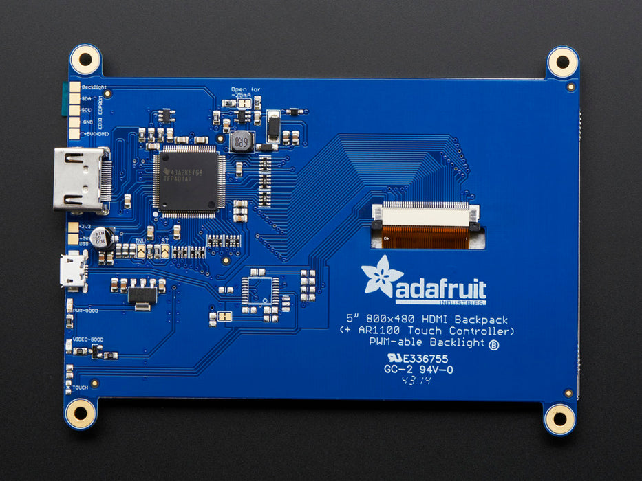 Top down view of a HDMI 5" Display Backpack - Without Touch connected to a Raspberry Pi powered by a USB. The HDMI screen displays a desktop image including the Raspberry Pi logo. 