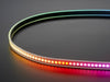 Shot of lightly coiled LED strip glowing rainbow colors.