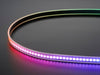 Shot of lightly coiled LED strip glowing rainbow colors.