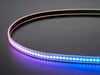 Shot of lightly coiled LED strip glowing rainbow colors.