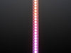 Shot of lightly coiled LED strip glowing rainbow colors.