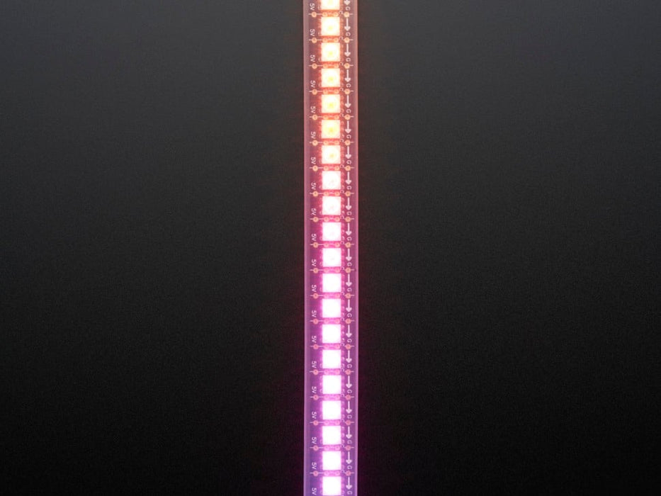 Shot of lightly coiled LED strip glowing rainbow colors.