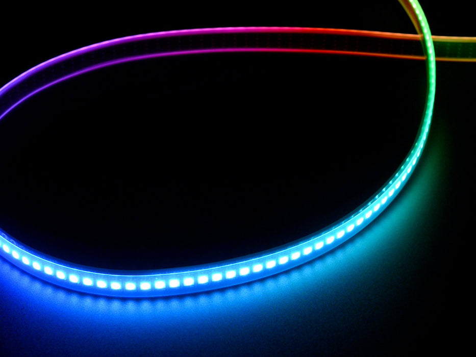 Shot of lightly coiled LED strip glowing rainbow colors.