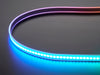 Shot of lightly coiled LED strip glowing rainbow colors.