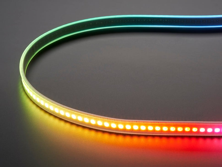 Shot of lightly coiled LED strip glowing rainbow colors.